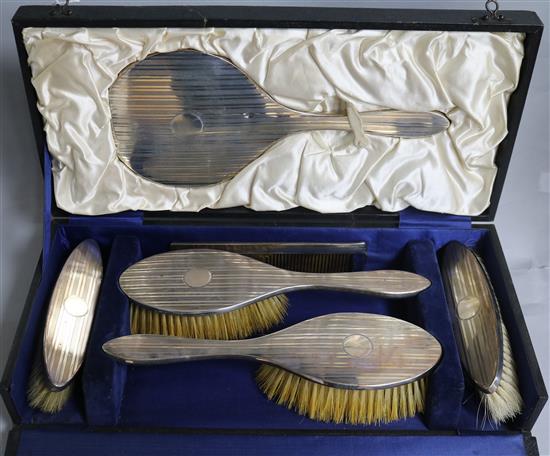 A cased George V engine turned silver six piece brush and mirror set.